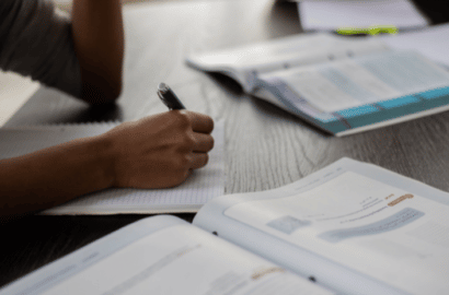 Woman sitting at table with an open workbook in front of her