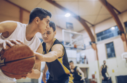 Two high school students playing basketball in a private school gym